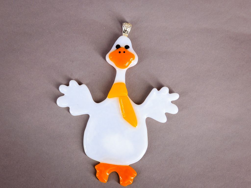 Hvid håndlavet glasgås med orange næb, fødder og gult tørklæde.