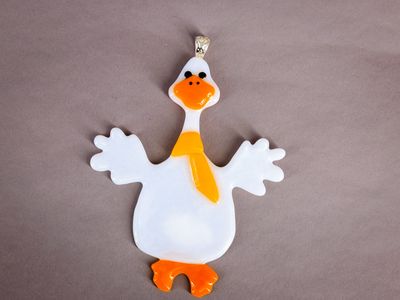 Hvid håndlavet glasgås med orange næb, fødder og gult tørklæde.