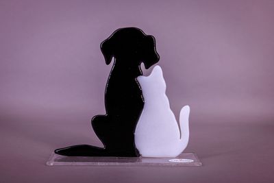 Glasfigur, Sammen – hund & kat i glaskunst Håndlavet glasfigur med sort hund og hvid kat siddende tæt sammen på en klar glasfod.