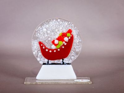 Glasfigur, snekugle, kane med gaver, på glasfod Rød julemandskane fyldt med farverige gaver i rundt glasmotiv med sne.