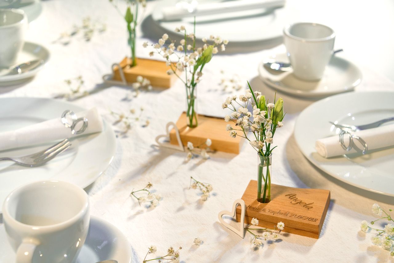Holzstück ohne Rinde und mit einem Reagenzgläschen mit Gänseblumen