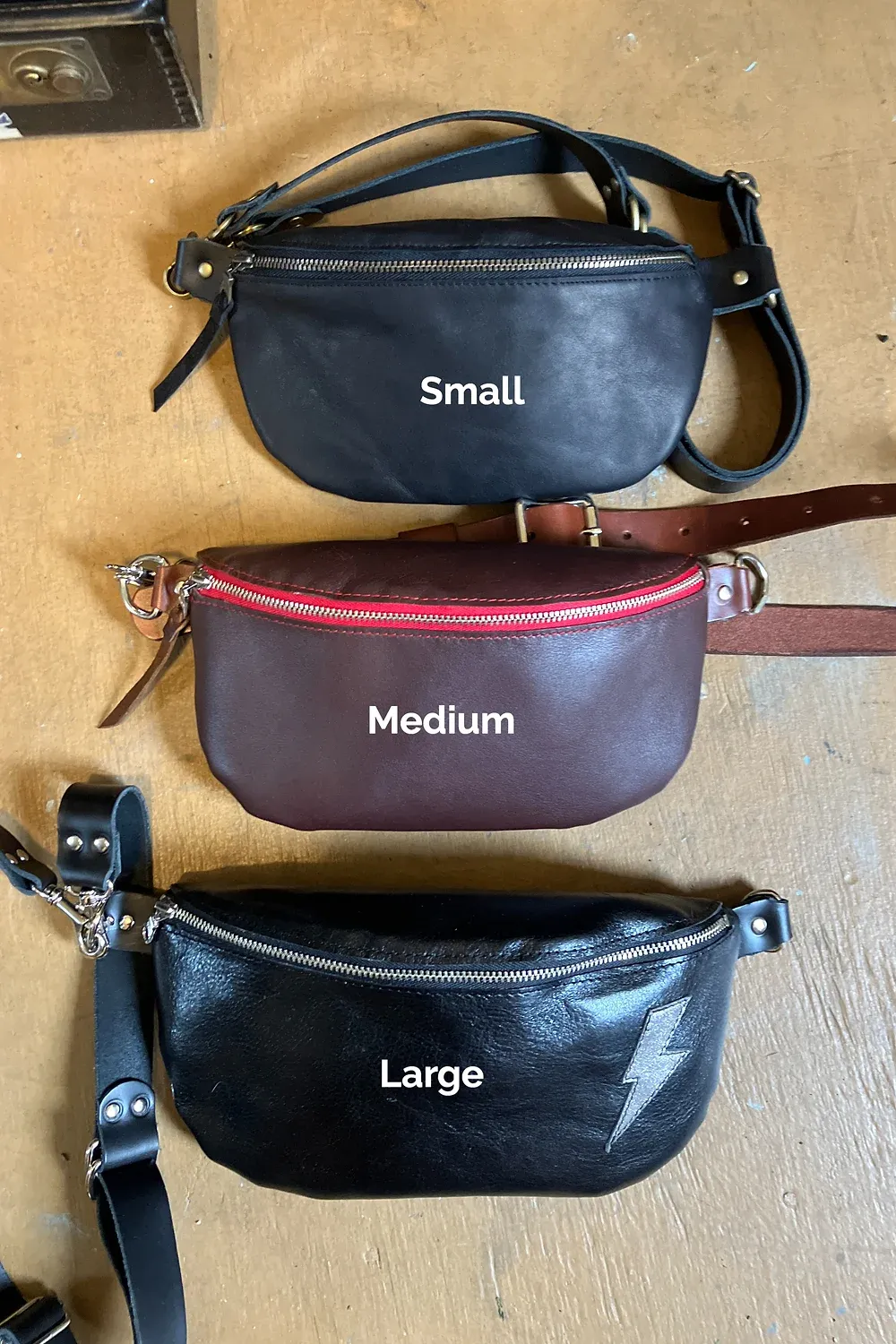 Body pouch displayed on a mannequin - featuring the leather texture (slightly shiny) and silver lightening bolt on front