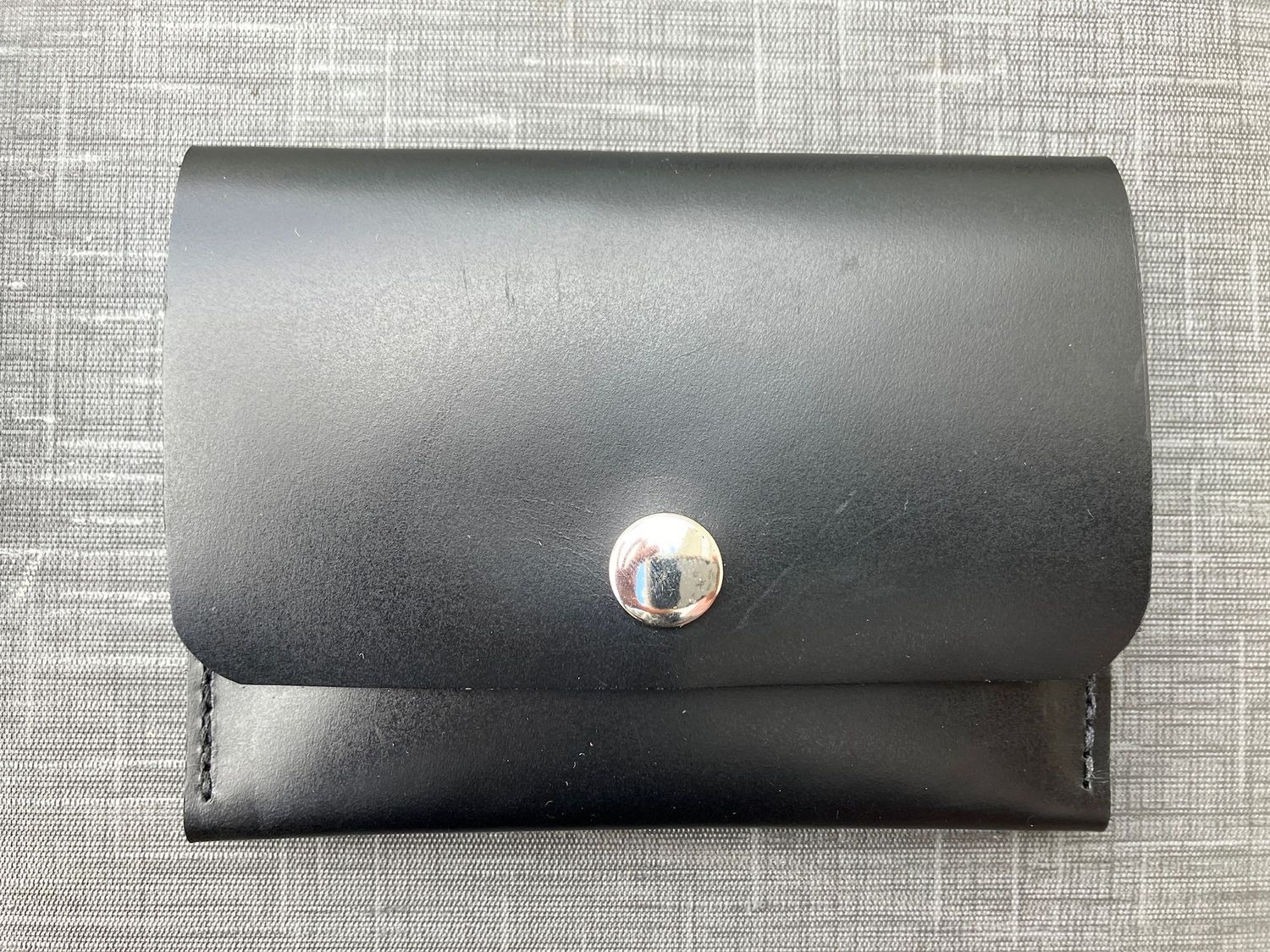 An image of the Medium snap wallet in black leather with silver snap