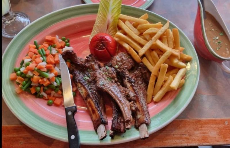 Lamb Chops (All Our Steaks aer served with French Fries, Tossed Vegetables and a Choice of any of the following sauce: A plate of perfectly grilled lamb chops, seasoned with herbs and spices, with a golden-brown crust on the outside and tender, juicy meat inside. Garnished with fresh rosemary and served alongside a side of roasted vegetables for a complete and flavorful meal.