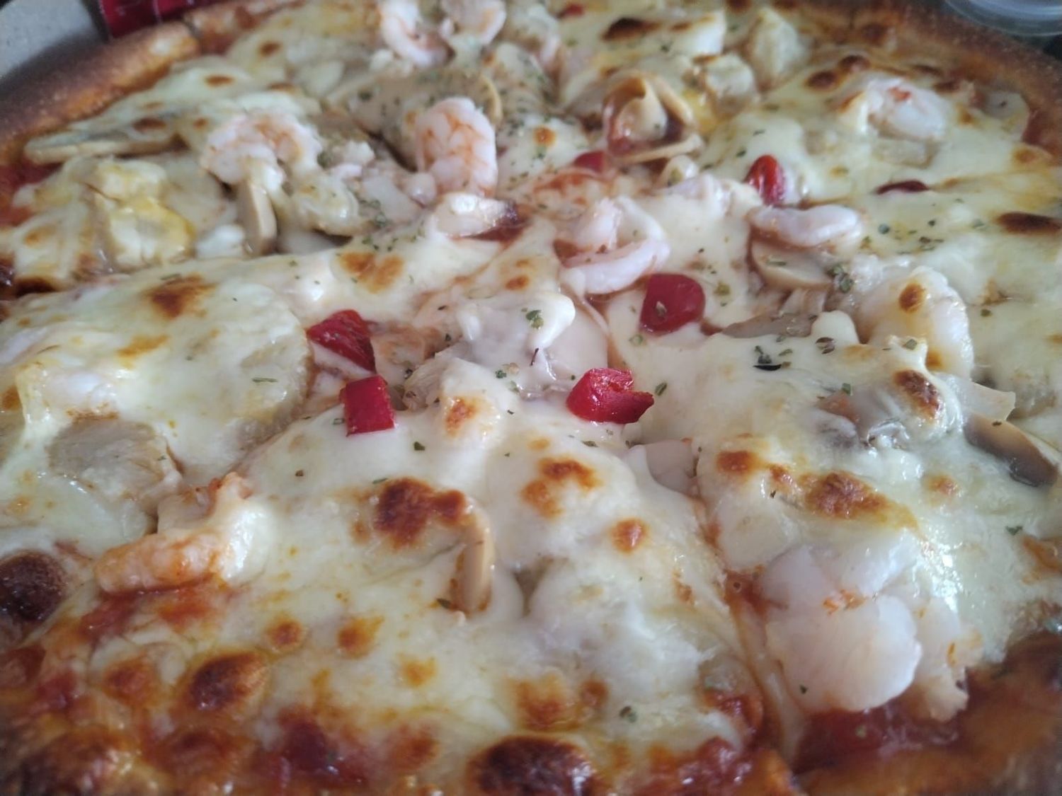 
"Pizza Gambretto at Pizza Corner UAE - Topped with Cheese, Shrimps, Mushrooms, Artichokes, and Pimentos"