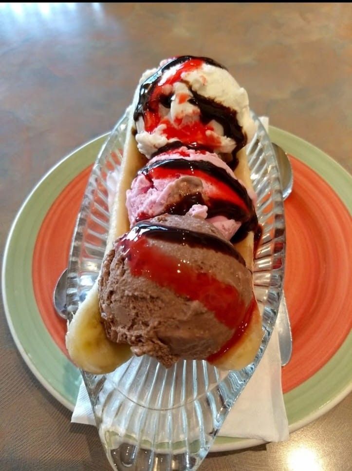 "Banana Split at Pizza Corner UAE - Fresh Banana with Scoops of Ice Cream, Topped with Whipped Cream, Chocolate Sauce, and Cherries"