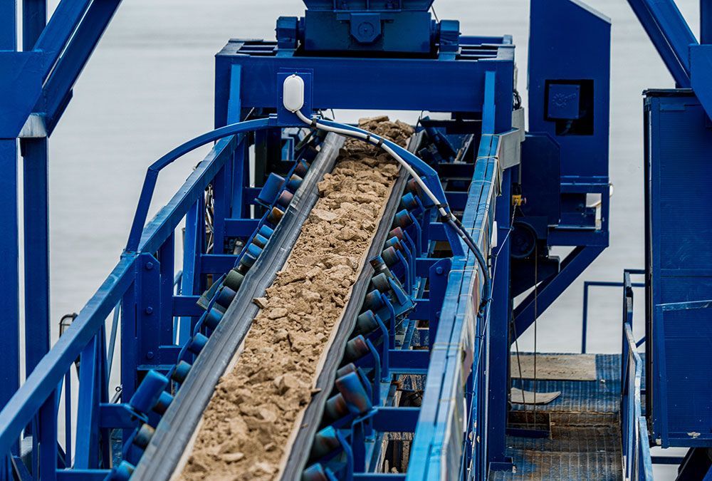 Convoyeur bleu transportant de la terre et des gravats