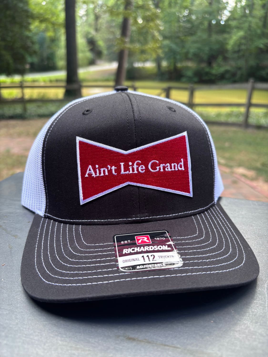 Ain't Life Grand Black/White Trucker Hat