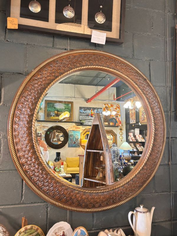 ORNATE ROUND MIRROR WITH A CURVED OR MOLDED FRAME
