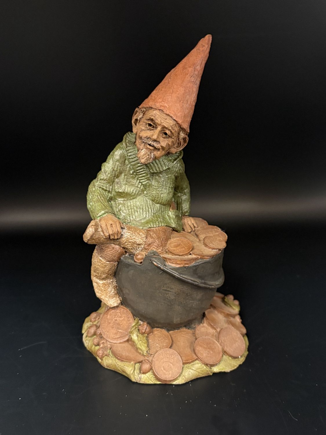 Sculpted Figure. USA. Tom Clark. Zurich. Signed. Gnome in Green Shirt, Sitting on a Pot of Coins. 1984. 8&#39;&#39;H