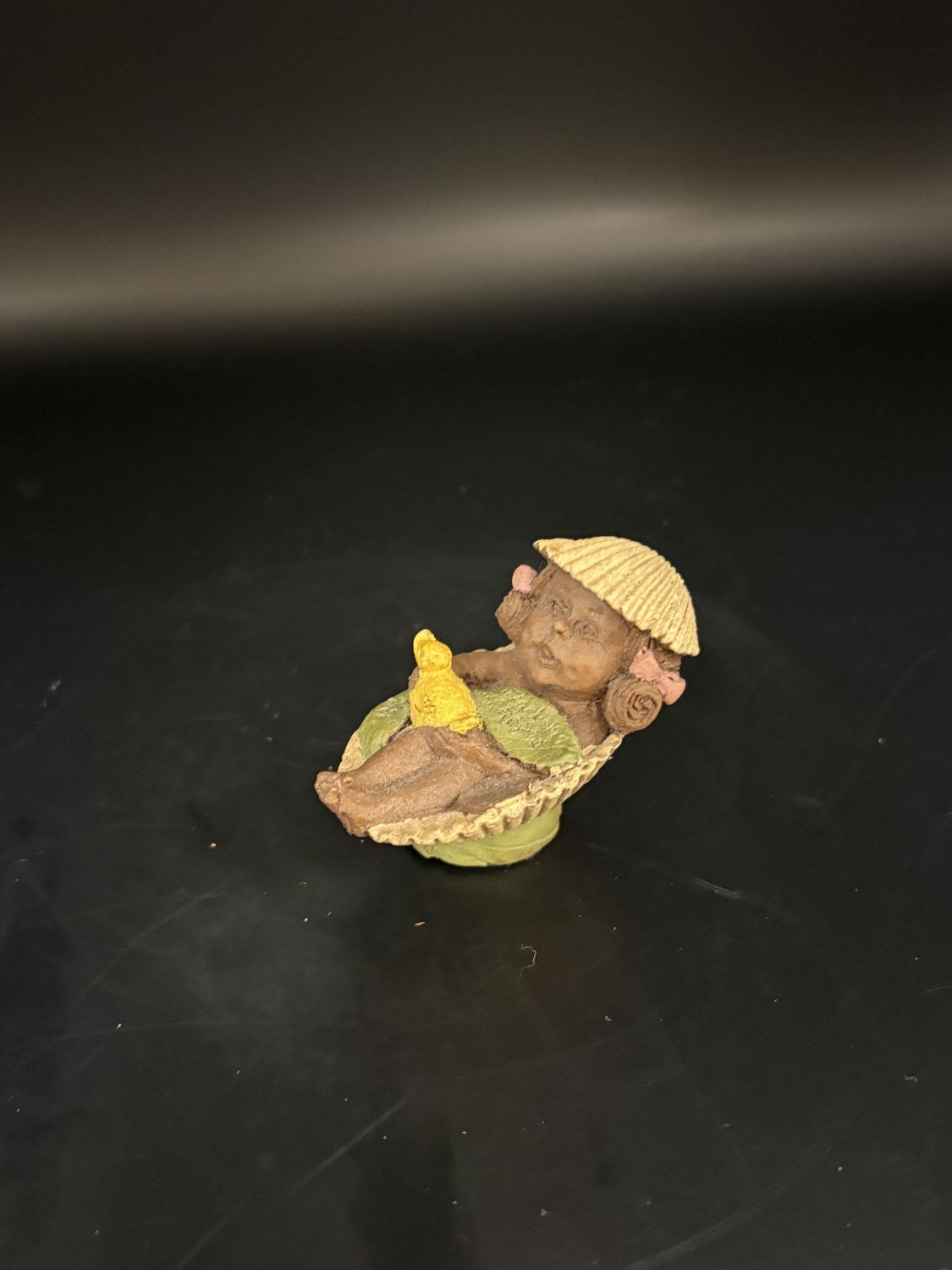 Sculpted Figure. USA. Tom Clark. Darcy. Small person sleeping in a sea shell while also wearing one as a hat. 2&#39;&#39;H.