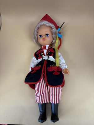 Doll. Polish Folk Girl. Blonde Hair. Vest. Red and White Striped Pants and Black Boots.