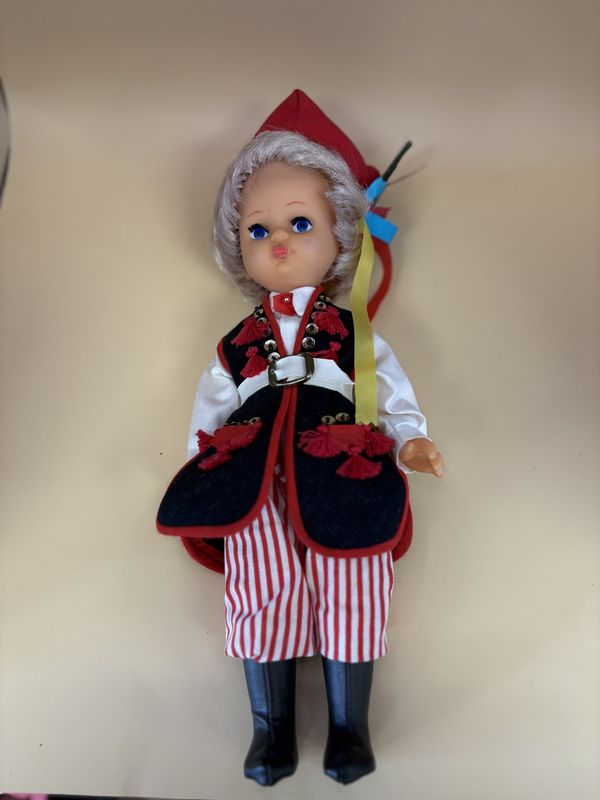 Doll. Polish Folk Girl. Blonde Hair. Vest. Red and White Striped Pants and Black Boots.