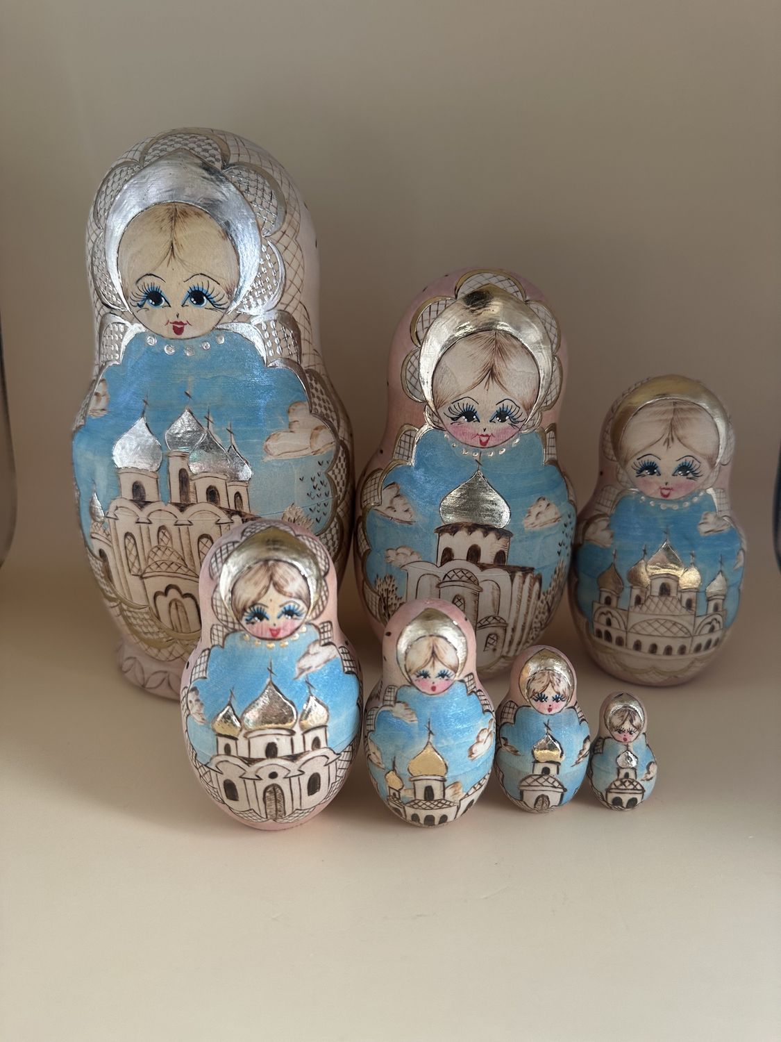 Doll. Russia. Ceprueb Nocag. 7-Piece Russian Matryoshka (Wooden Nesting Doll)  Set. Wood Burned Design &amp; Hand-painting. Beige, Pale Pink, Teal &amp; Silver. 8&quot;H