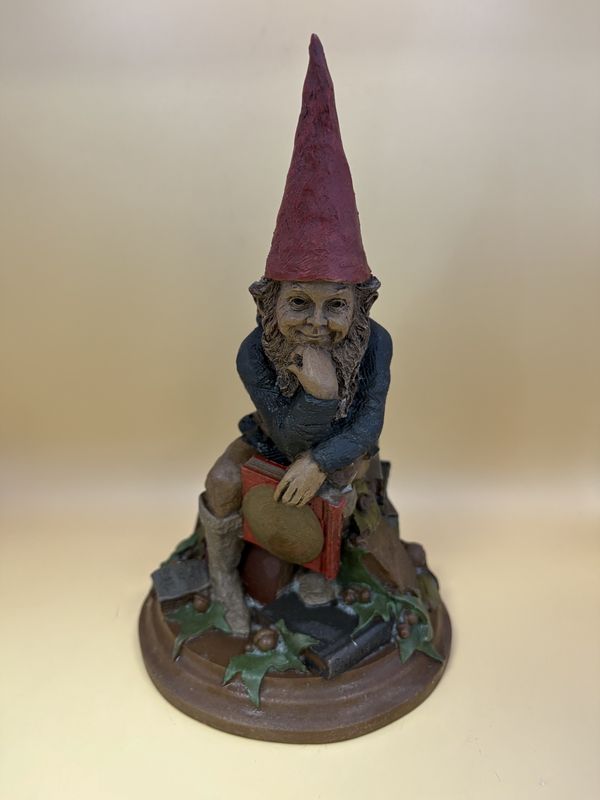 Sculpted Figure. USA. Tom Clark. Signed. Curtis. Gnome Sitting on Pile of Books; One Hand is Resting His Chin &amp; the Other is Holding a Book. 1985. 8.5&quot;H