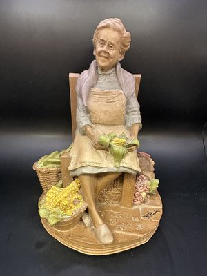 Sculpted Figure. USA. Tom Clark. Signed. Leah. Woman in Blue Dress Sitting in Wooden Chair &amp; Shucking Corn. 1986. 8.75"H