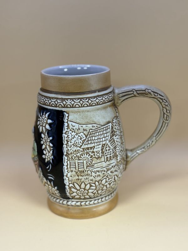 Stein. Brazil. Ceramarte. Two Men and a Woman, w/Edelweiss  &amp; Houses. Tan &amp; Blue. 6&quot;H