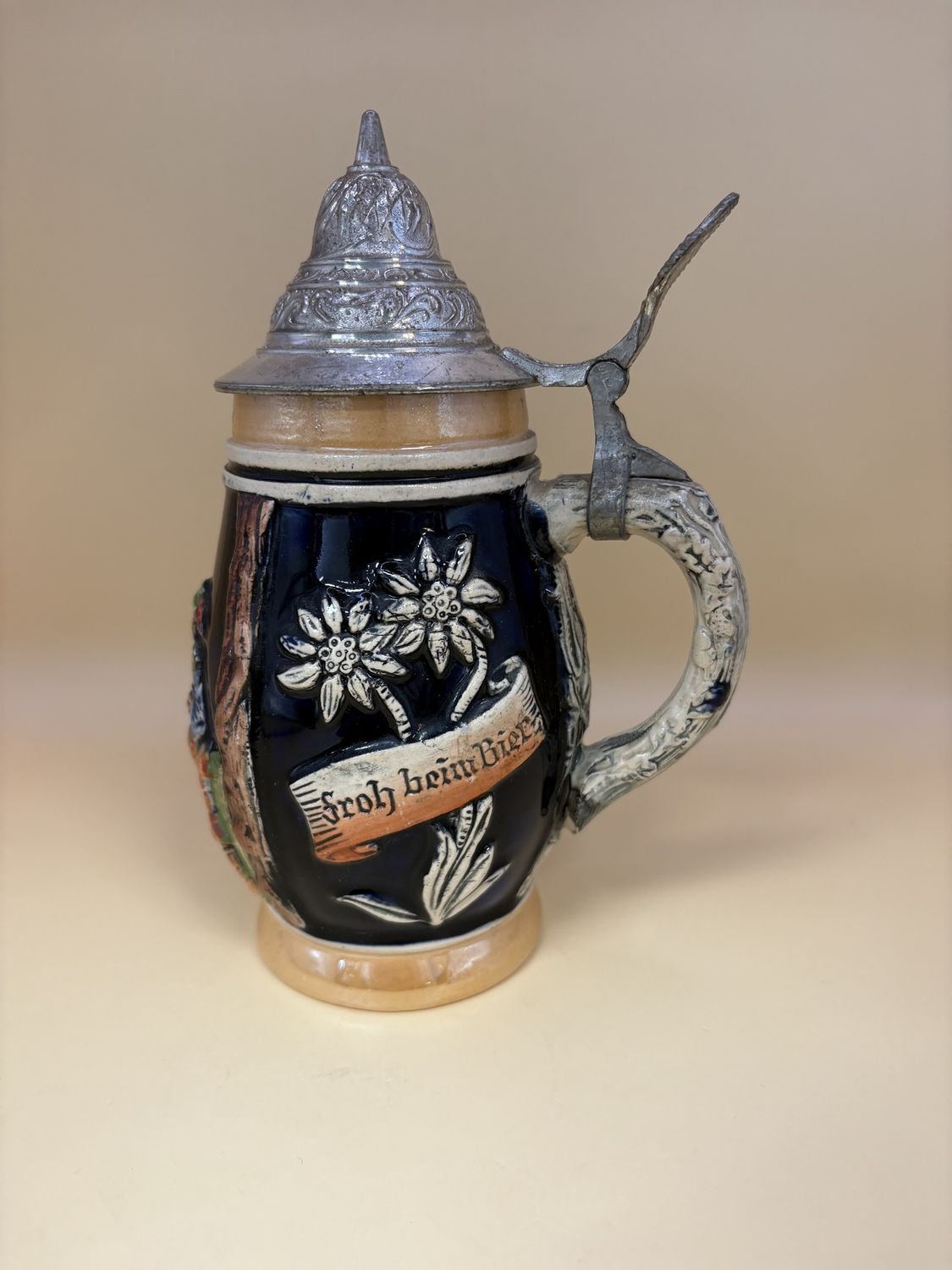 Stein. West Germany. Two Women and a Man at a Table w/ Flowers on Sides and Text &quot;Daslieber wir&quot; &quot;Froh bein Bier.&quot; 7.5&quot;H