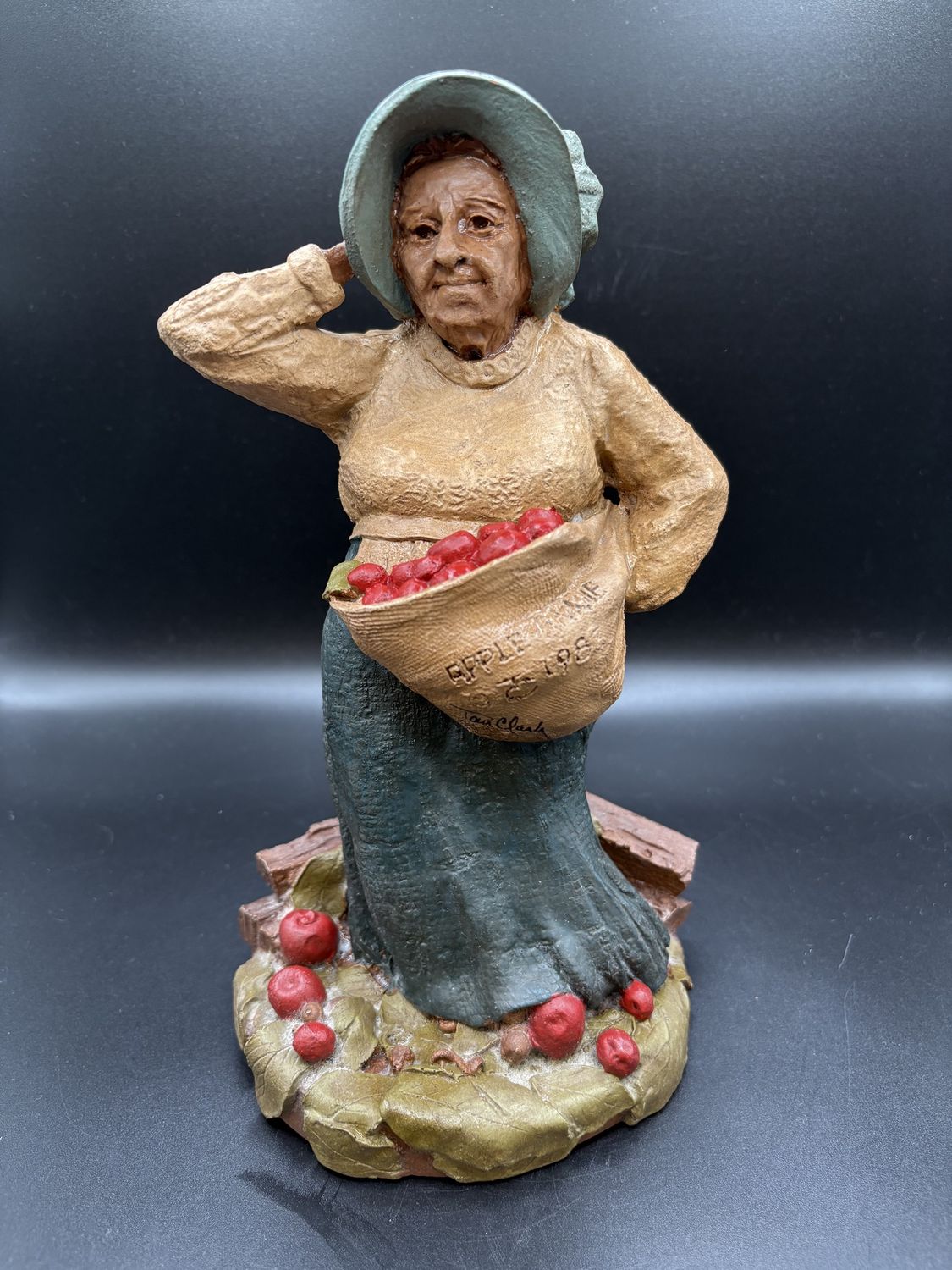Sculpted Figurine. USA. Tom Clark. &quot;Apple Annie&quot; Older Woman Carrying Apples. 1983. Signed. 9&quot;H