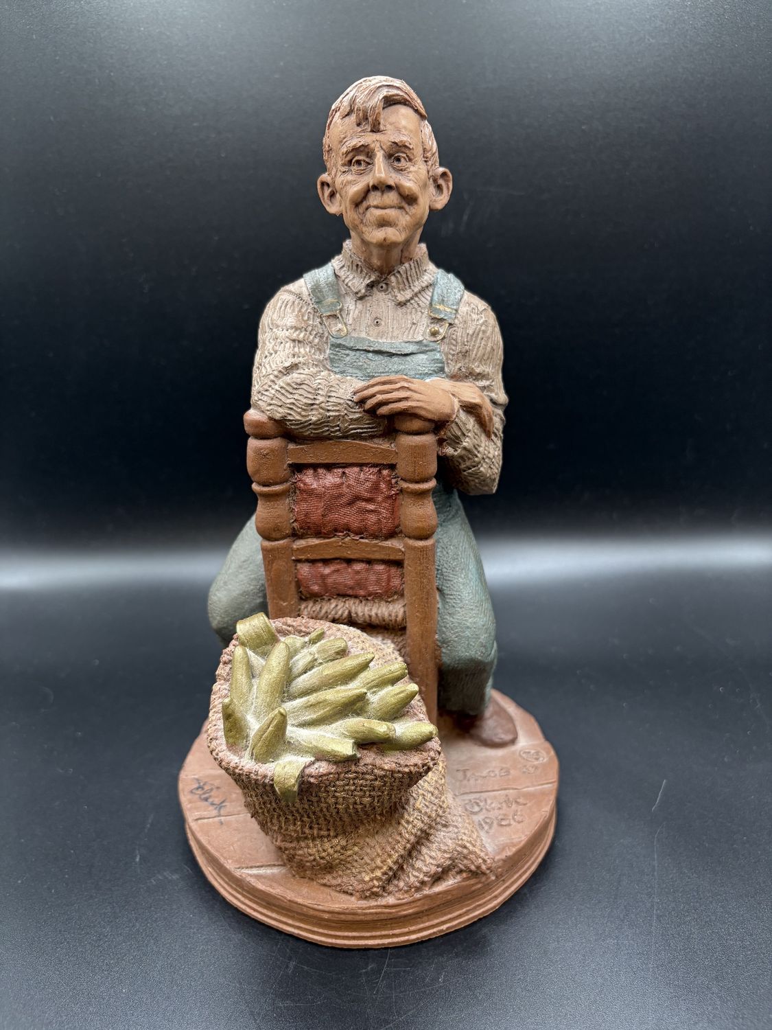 Sculpted Figure. USA. Tom Clark. &quot;Jacob.&quot; Man Sitting in Backwards Chair w/ Vegetables. 1986. Signed. 10&quot;H