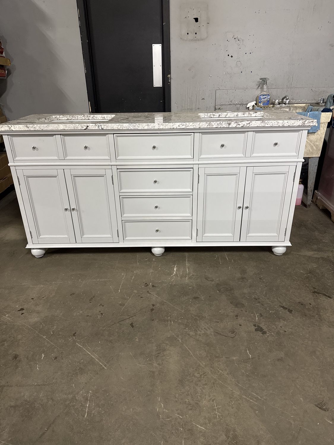 72in. X 22in.  Light gray vanity with granite top and double sinks.