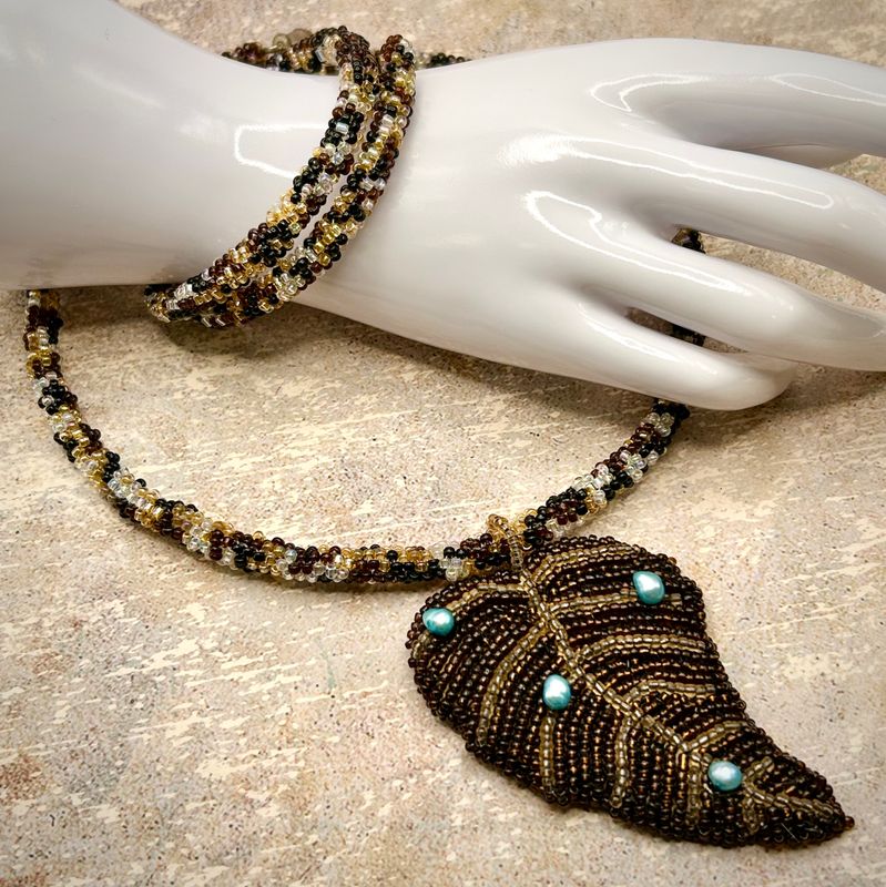 Beaded jewelry set featuring bead embroidered autumn leaf pendant