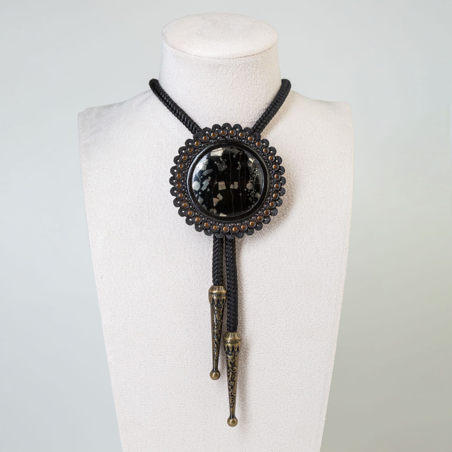 Handmade bolo tie with pyrite in onyx, framed in tooled leather - Exclusive tooled leather pendant - Stylish jewelry by GemsPlusLeather