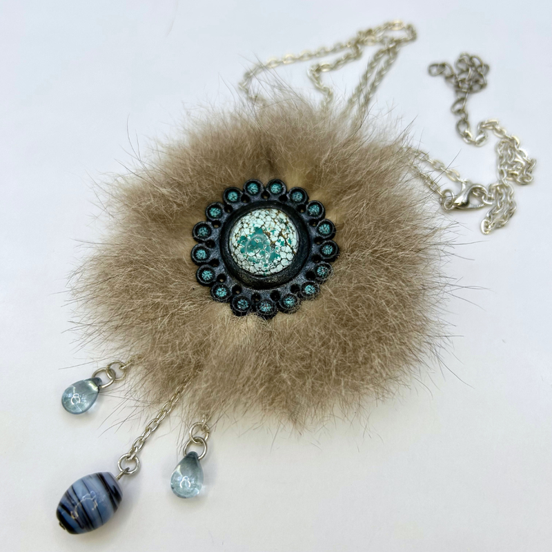 Mixed media necklace with turquoise cabochon framed in tooled leather