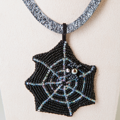 Tooled leather Gothic necklace imitating a hammered silver with a pendant featuring a pearl spider sitting on a bead embroidered spider web
