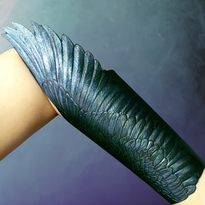 Pair of hand tooled black leather winged bracers with metallic sheen