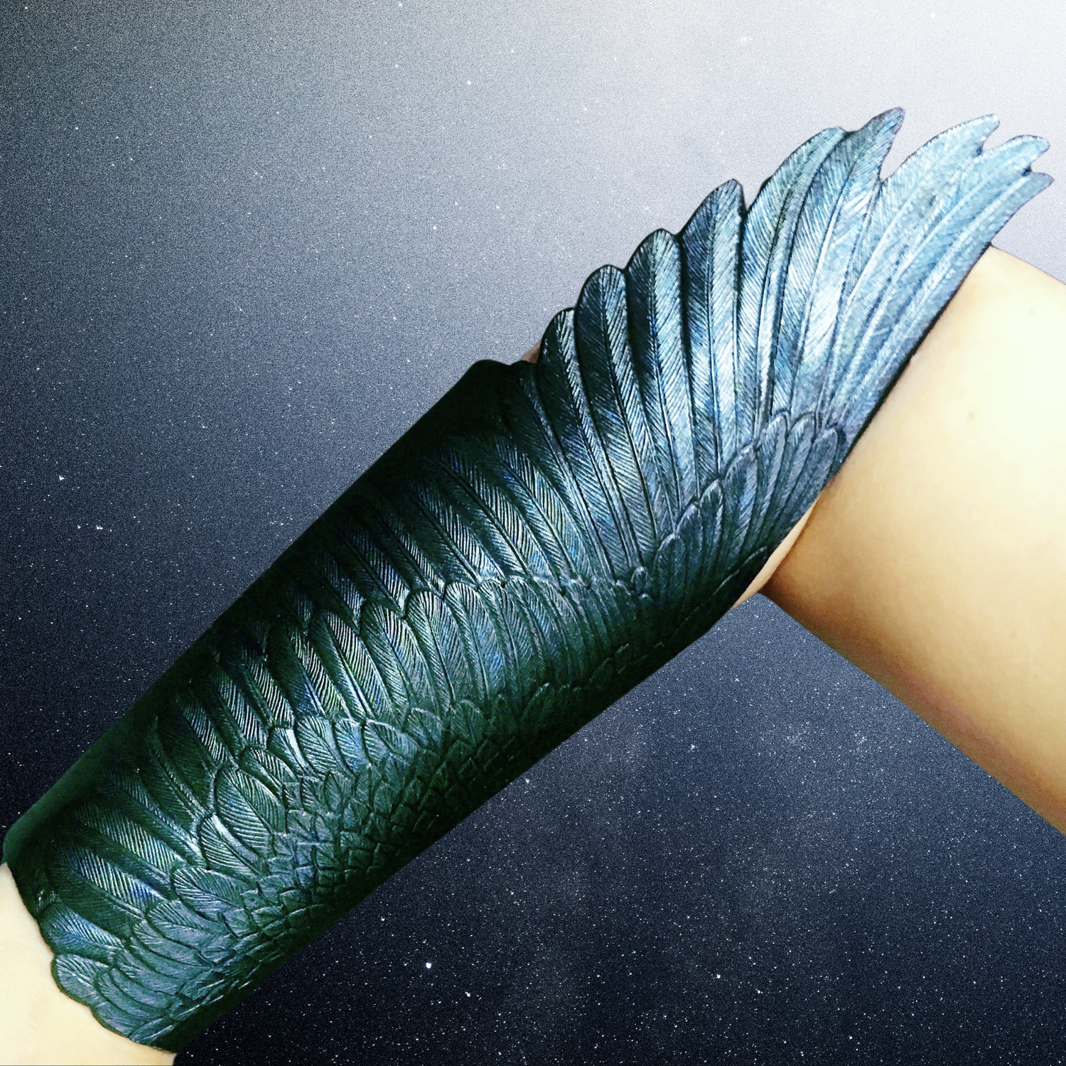 Pair of hand tooled black leather winged bracers with metallic sheen