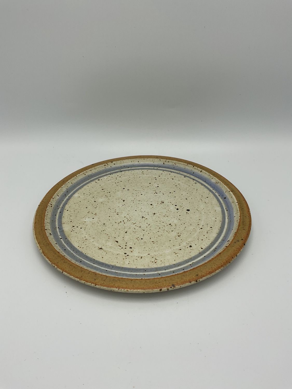 Kelly McCarty stoneware plate, blue &amp; brown ring on cream