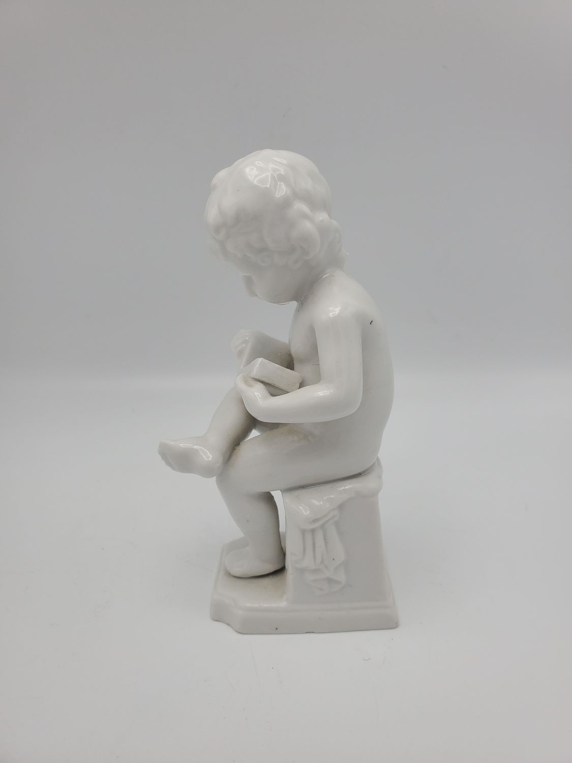 Boy reading book porcelain statue