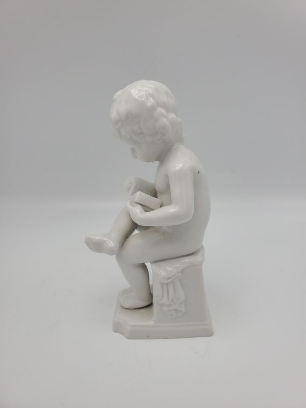 Boy reading book porcelain statue