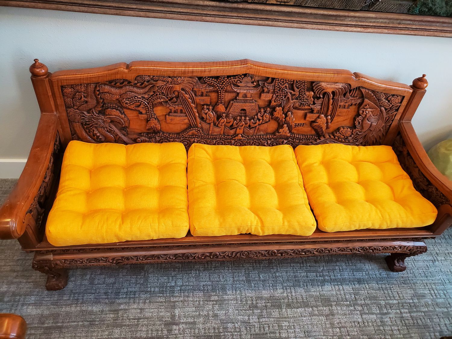 Ornate hand carved couch with yellow cushions