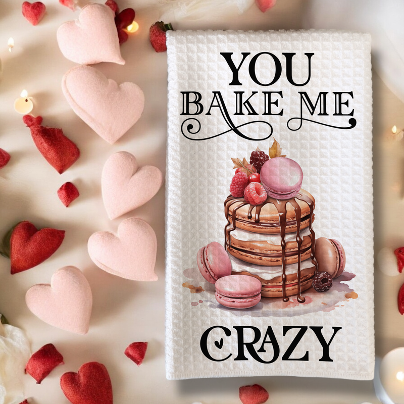 Keukenhanddoek met de tekst &#39;You Bake Me Crazy&#39;, versierd met een stapel pannenkoeken, roze macarons en bessen. Perfect Valentijnscadeau.