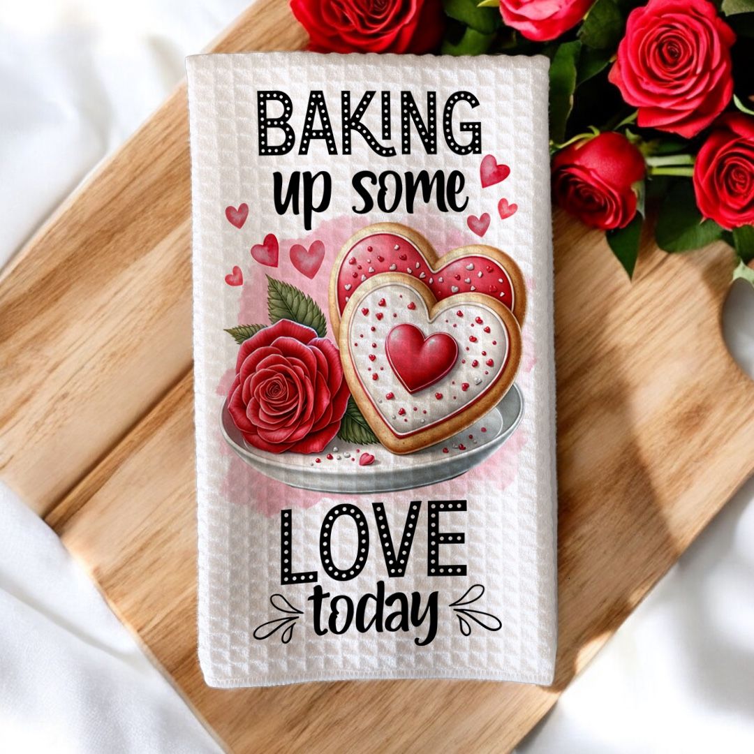 Valentijnskeukenhanddoek met de tekst &#39;Baking Up Some Love Today&#39;, versierd met een illustratie van hartvormige koekjes, rode rozen en romantische details. Perfect geschenk voor Valentijn.