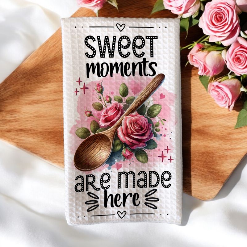 Keukenhanddoek met de tekst &#39;Sweet Moments Are Made Here&#39;, versierd met een houten lepel, roze rozen en romantische accenten. Perfect als Valentijnscadeau.