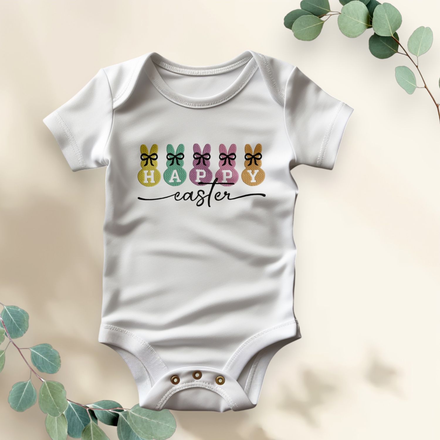 Witte baby romper met pastel paashaasjes, strikjes en de tekst &quot;Happy Easter&quot;, ideaal voor Pasen.