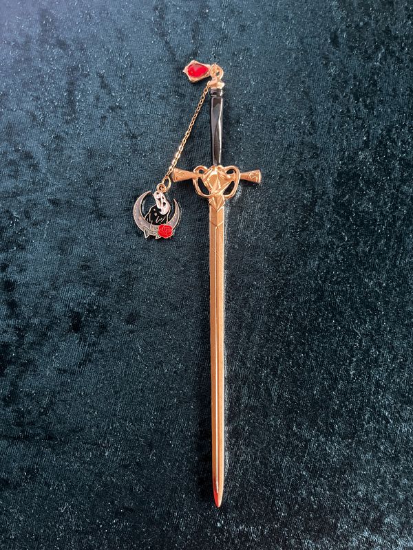 Lesezeichen "Schwert" in Gold-Optik, mit schwarzem Griff, mit rotem Stein, Kettchen und Anhänger "Rabe, Schädel, Rose  & Halbmond"