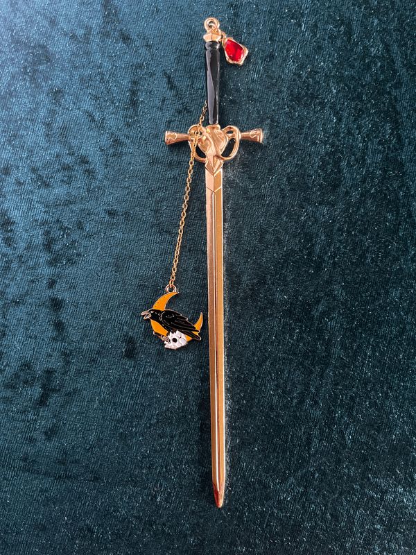 Lesezeichen "Schwert" in Gold-Optik, mit schwarzem Griff,  mit rotem Stein, Kettchen und Anhänger "Rabe, Schädel & Halbmond"