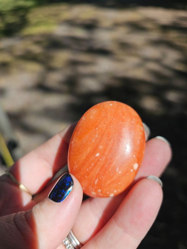 Orange calcite palm stone