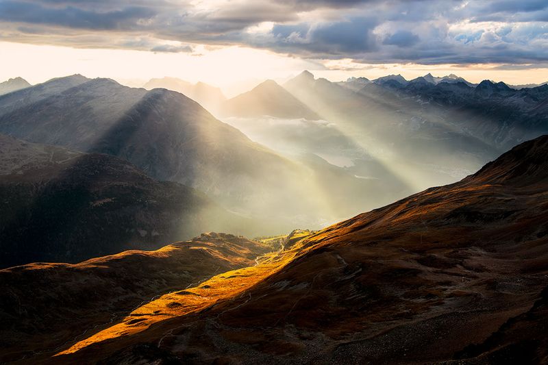 Atemberaubende Aussicht von der Alp Languard in Pontresina auf die Alpen im Oberengadin mit dramatischen Sonnenstrahlen 