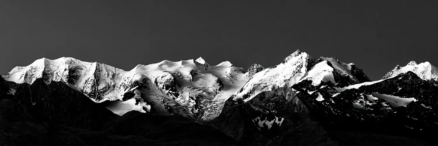 ramatisches Schwarzweiß-Panorama der schneebedeckten Berninagruppe in den Schweizer Alpen