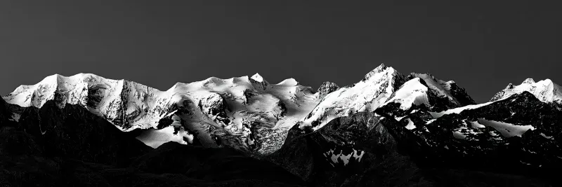 ramatisches Schwarzweiß-Panorama der schneebedeckten Berninagruppe in den Schweizer Alpen