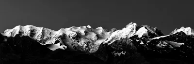 ramatisches Schwarzweiß-Panorama der schneebedeckten Berninagruppe in den Schweizer Alpen