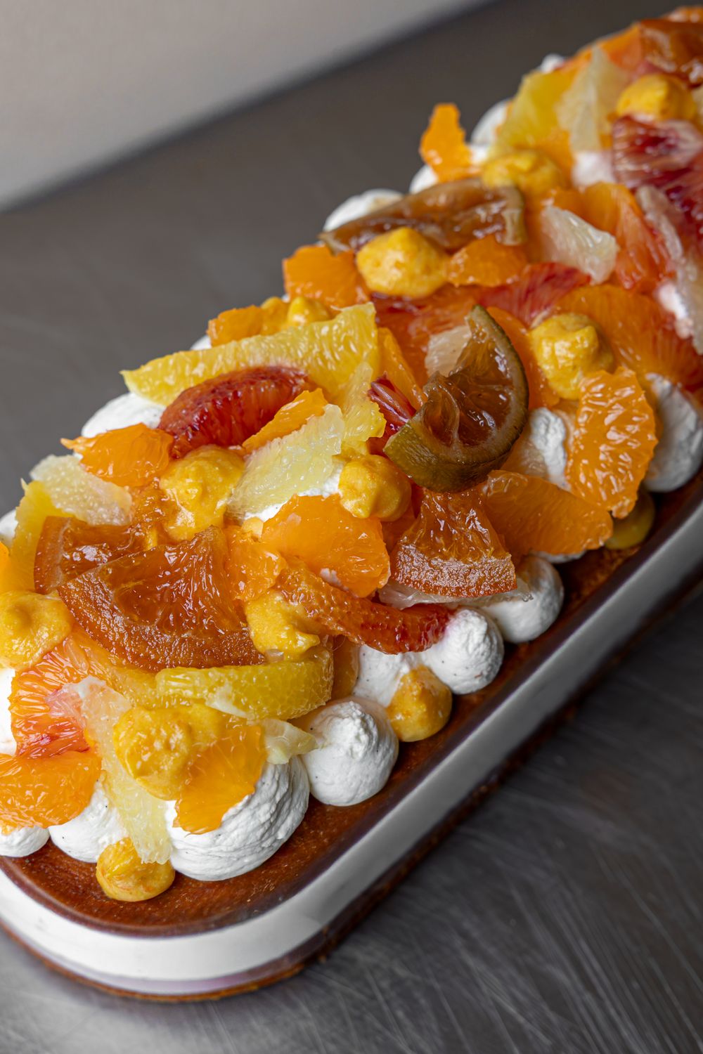 Dessert agrumes (6-8 pers) : crème montée vanille, marmelade de clémentines, suprêmes d&#39;agrumes (clementines, citrons verts, oranges et oranges sanguines) sur moelleux au jus de clémentines.