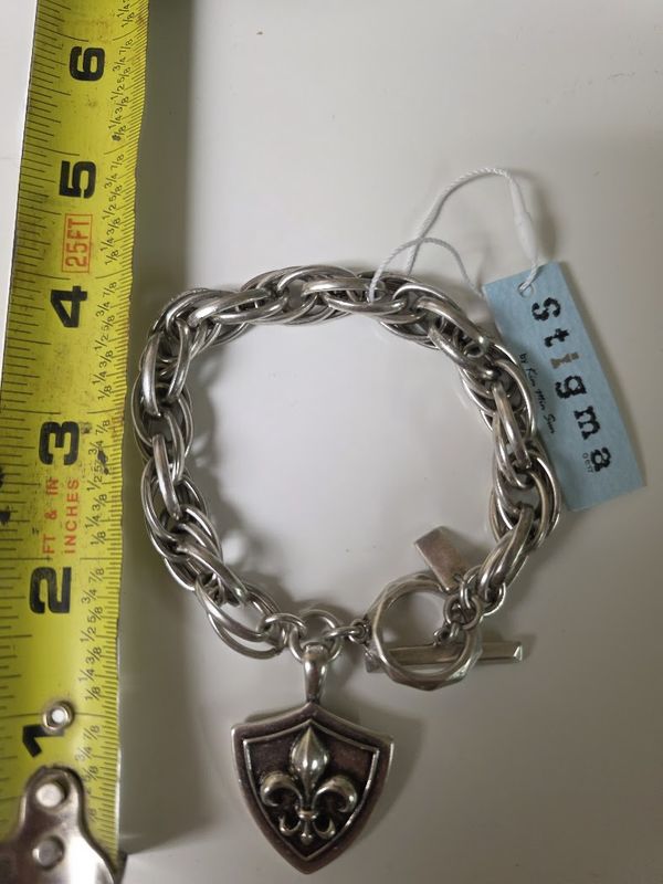 Stigma men's bracelet with a toggle clasp and a shield charm featuring a fleur-de-lis emblem