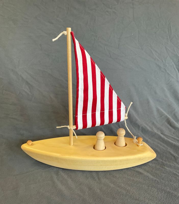 wooden toy sailboat, red and white stripe sail