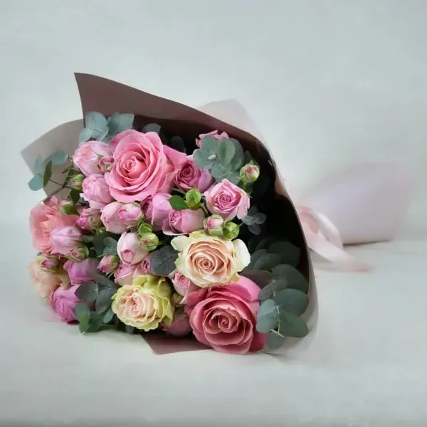 The bouquet is made of roses in pink tones.